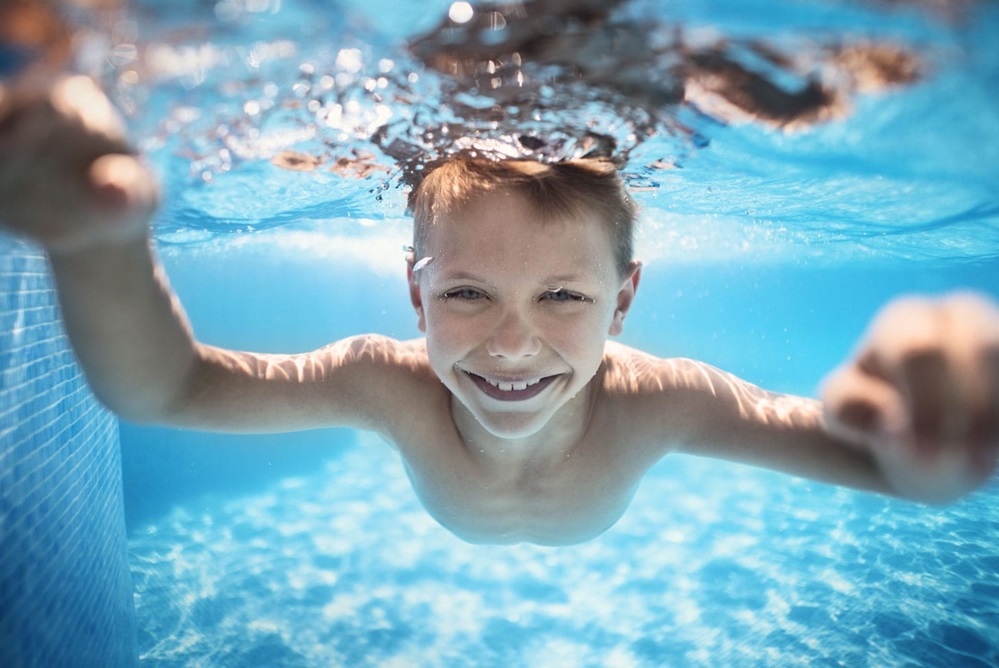 Boy swimming underwater with his eyes open